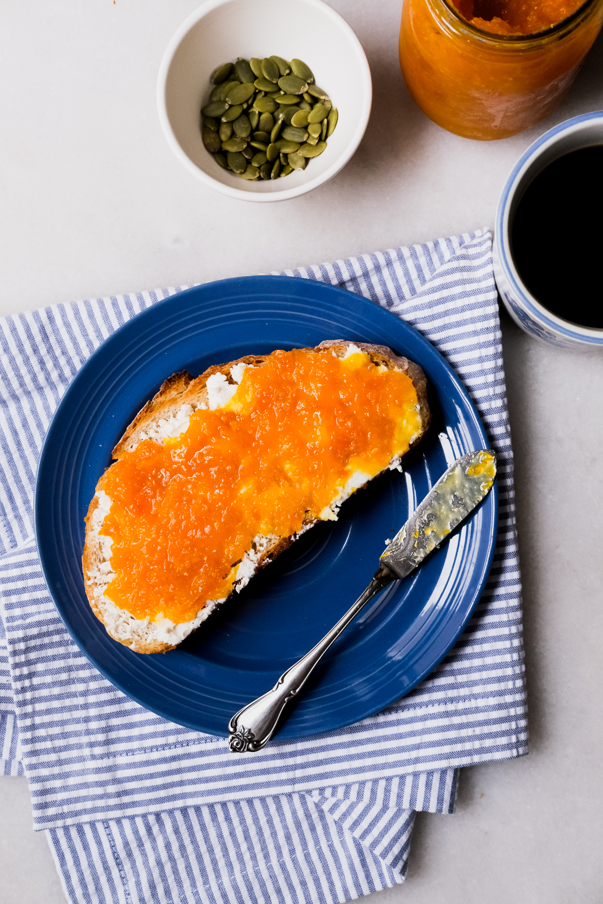 spreading tangerine jam on ricotta toast